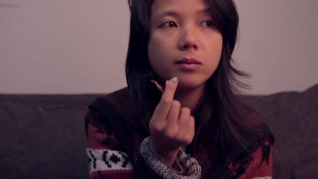 Pretty Asian girl eating beef jerky