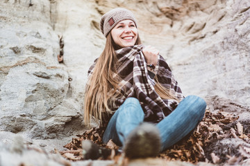 Attractive young woman sitting in a pile of leaves