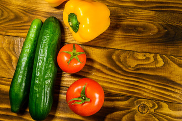 Cucumbers, tomatoes and sweet pepper on wooden table. Top view