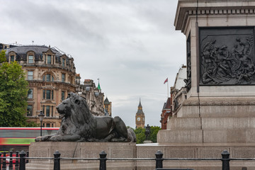 Statue of Lion on Trafalgar Square, on background Big Ben in London, United Kingdom
