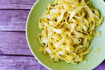  Fresh Tagliatelle  vegetarian pasta with parmesan cheese  and black pepper  .Dark plate  on  dark background.Mediterranean diet Restaurant menu