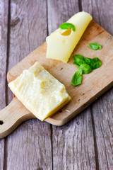 Parmesan and  Maasdam    Emmental-style Dutch cheese and fresh basil on wooden board