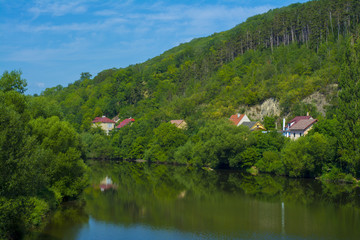 The bend of a river with several houses on a hill in Europe
