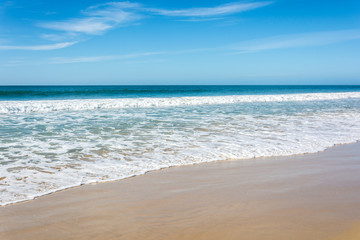 Waves breaking on beach with blue sky - Port Elizabeth, South Africa