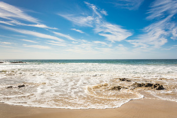 Waves breaking on beach with blue sky - Port Elizabeth, South Africa