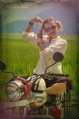 young woman relaxes sunbathing on a red motorcycle