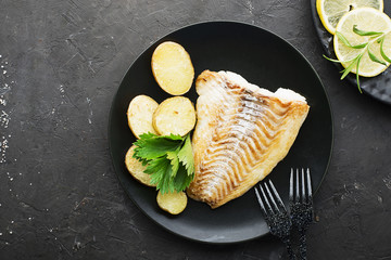 Cod fillet baked with fresh farmer's vegetables: potatoes, carrots, onions. Top View,