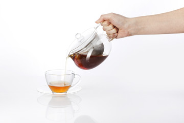 woman hand hold a pure tea bottle to the cup isolated white.