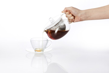 woman hand hold a pure tea bottle to the cup isolated white.