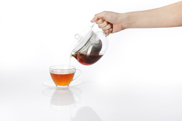 woman hand hold a pure tea bottle to the cup isolated white.