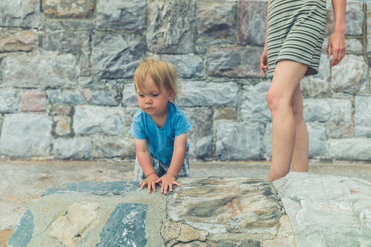 Mother and toddler by stone wall