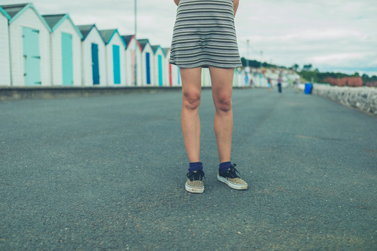 Young woman standing by beach huts