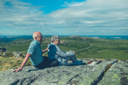Senior couple relaxing on rock in the moor