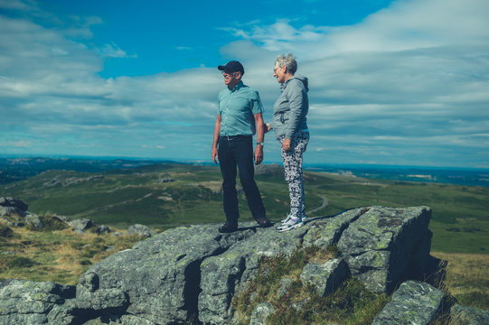 Senior couple standing on rock in the moor
