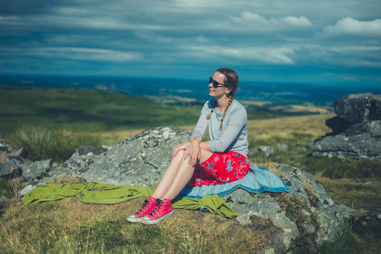 Young woman sitting on  rock in the moor