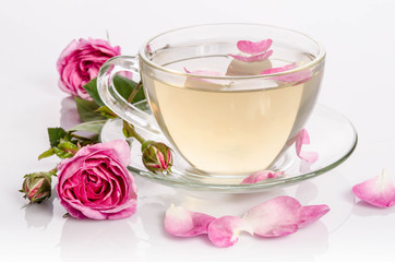 Glass cup of Tea with roses and petals