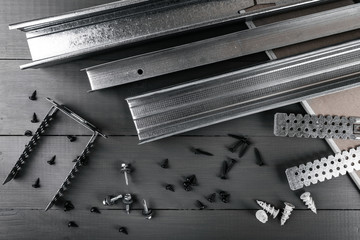 plasterboard profiles and fasteners on gray background. top view