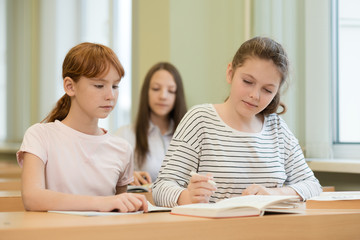 3 student girls are sitting at a Desk