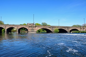 View of the River Trent and weir towards the Trent Bridge road bridge A511, Burton upon Trent, UK.