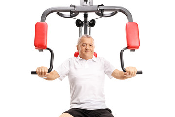 Mature man exercising on a multifunctional machine