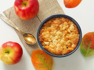 Portion of coffeecake in blue bowl. Biscuit with autumn apples. Homemade crumble pie with crumbs...
