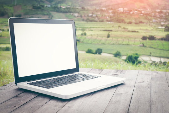 Blank screen laptop on the background picturesque nature, outdoor office. Travel concept. Business ideas. Choice of travel. Copy space. Online store.