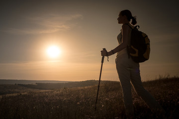 Silhouette hiker woman tracking with backpack