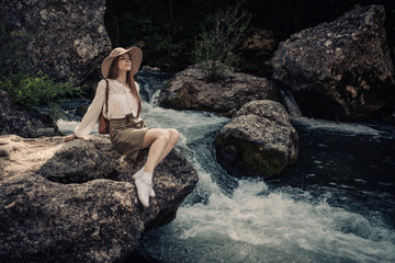 woman traveler with backpack and hat walking