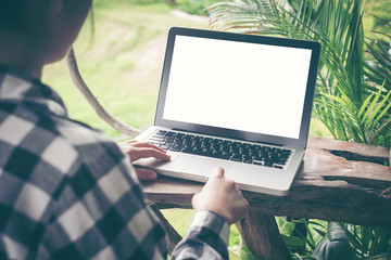Woman with blank screen laptop on table in coffee shop with vintage toned.