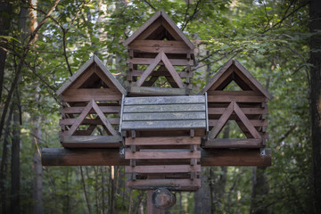 Fototapeta na wymiar Multi-storey bird feeder in a dense forest. Like a fairy-tale hut on chicken legs