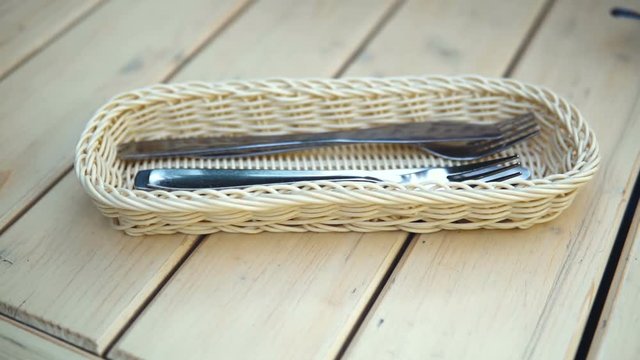 woman hand takes the knife and the fork on table