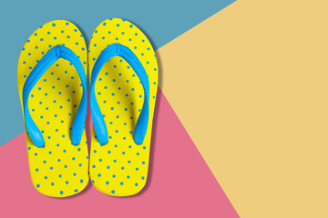 Yellow sandals on pink and blue color background, flat lay photo