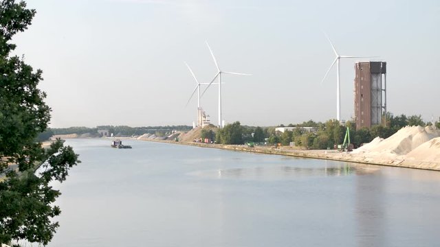 canal with barge and wind turbine