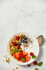 Bowl of homemade granola with yogurt and fresh berries