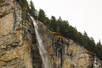 Beautiful autumn time at village of Lauterbrunnen in Swiss alps, gateway to famous Jungfrau. Set in a valley featuring rocky cliffs and the roaring