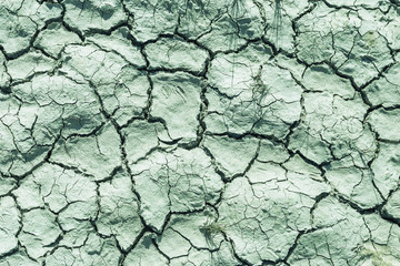 a close-up of deep cracks on the ground due to a drought. The concept of ecological changes in nature