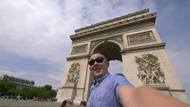 Man taking selfie with a view on Arc de Triomphe in Paris in 4k slow motion 60fps