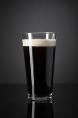 Draft Nitrogen Fresh and Creamy Black Stout Beer Pint over Black Background