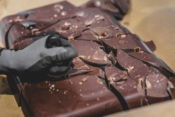 Person breaking big chocolate block into pieces