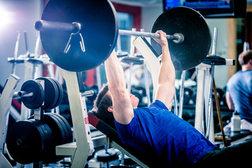 Man pressing barbell on incline bench.