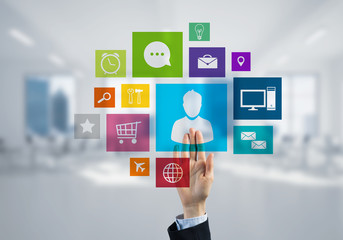 Modern office interior and close of businesswoman hand choosing icon on multimedia interface