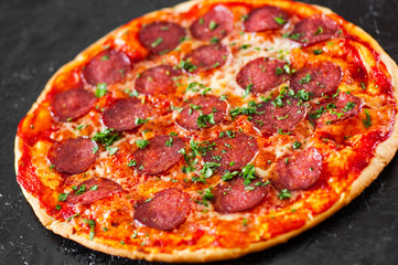 Pepperoni Pizza with Mozzarella cheese, salami, Tomatoes, pepper, Spices and Fresh Basil. Italian pizza
