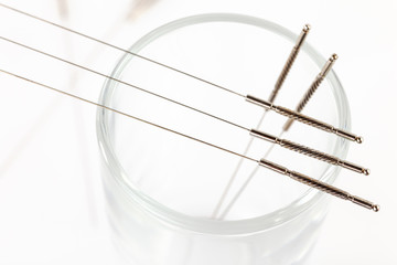 Silver needles for traditional Chinese medicine acupuncture. Close-up. White background.