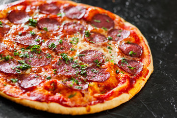 Pepperoni Pizza with Mozzarella cheese, salami, Tomatoes, pepper, Spices and Fresh Basil. Italian pizza