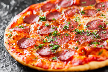 Pepperoni Pizza with Mozzarella cheese, salami, Tomatoes, pepper, Spices and Fresh Basil. Italian pizza
