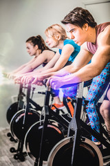 Fototapeta na wymiar Athletic people cycling in gym