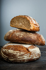 closeup three big handmade round black pieces of bread vertical