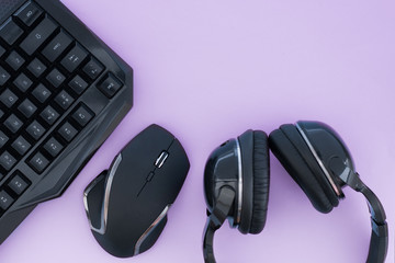 Headphones, mouse, keyboard on the pastel pink background, top view. Gaming gear. Gamer workspace...