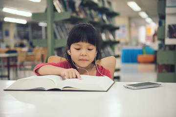 children girl read book at the library room