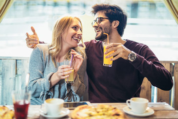 Smiling couple enjoying in pizza, having fun together.